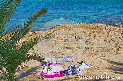 Portugal Beach towel with hat, sun glasses and flip flops on sand naturist Stock Photo