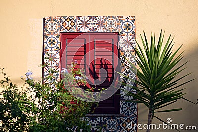 Portugal window. Costa de Caparica Almada. Authentic. Yellow wall. Palm. Janela de Portugal. Parede amarelo. Light and shadow. Stock Photo