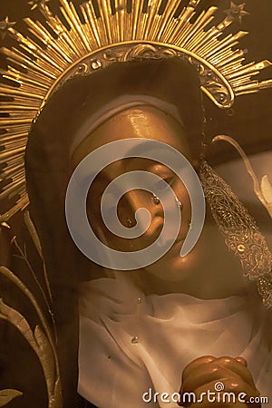 Statue of Virgin Maria with tears through glass filtered. Sculpture of Saint Maria with tears behind glass. Sadness and grief. Editorial Stock Photo