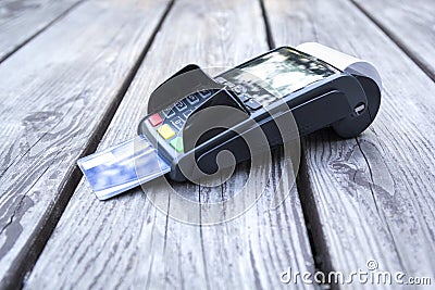 POS terminal, hand swiping credit card, payment with NFC tecnology on wooden background Stock Photo