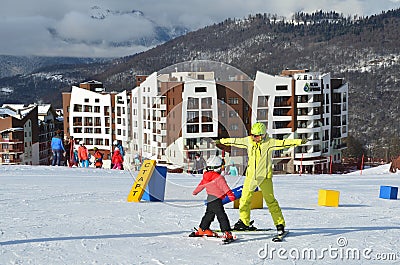 Posa Khutor, Sochi, Russia, January, 26, 2018. The instructor teaching little boy to go skiing on the child`s training slope in th Editorial Stock Photo