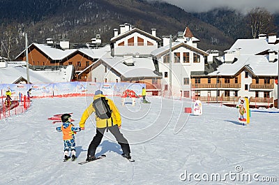 Posa Khutor, Sochi, Russia, January, 26, 2018. The instructor teaching little boy to go skiing on the child`s training slope in th Editorial Stock Photo