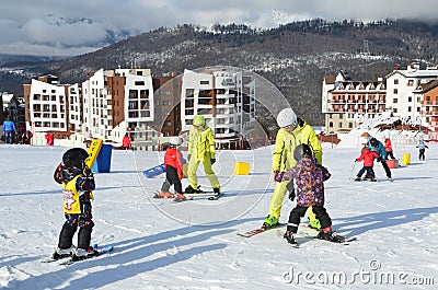 Posa Khutor, Sochi, Russia, January, 26, 2018. The instructor teaching little boys to go skiing on the child`s training slope in t Editorial Stock Photo