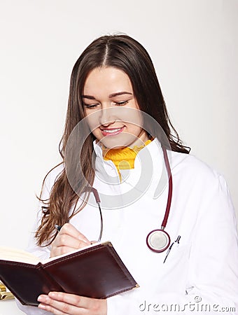 She poses in a doctor`s coat. With a book where she writes down her obligations. Ph2 Stock Photo