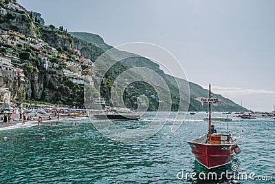 Positano, Italy - August 14, 2019: Man in red boat in front of Positano beach, Amalfi Coast Editorial Stock Photo