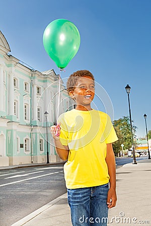 Positive African boy with green flying balloon Stock Photo
