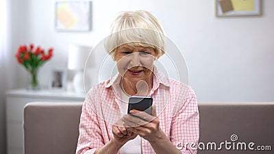 Positive aged woman using smartphone, online shopping, social network chatting Stock Photo