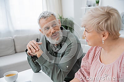 positive bearded man talking to blurred Stock Photo