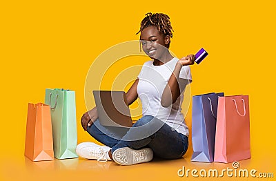Positive black girl shopping online, using laptop and credit card Stock Photo