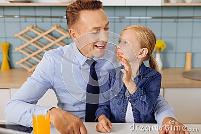 Positive blonde girl giving a cookie to her dad Stock Photo