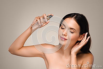 Positive calm millennial european lady apply spray on hair, enjoy beauty care treatment Stock Photo