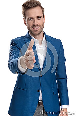 Positive casual man going for a handshake and smiling Stock Photo