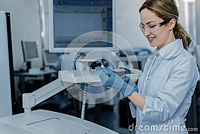 Positive cheerful woman working with scientific equipment Stock Photo