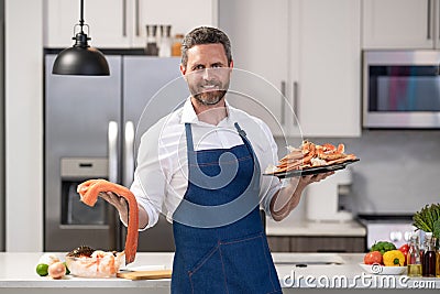 positive chef cooking lobster and salmon seafood. chef with lobster and salmon seafood Stock Photo