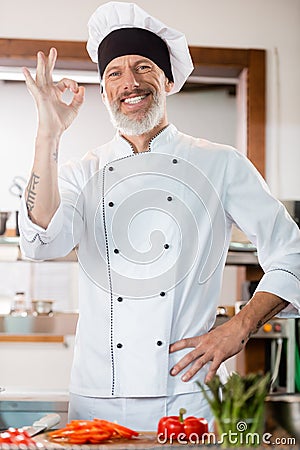Positive chef showing ok gesture near Stock Photo