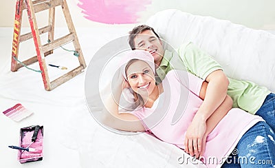 Positive couple lying on a sofa after painting Stock Photo