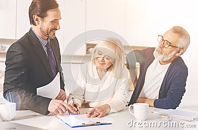 Positive couple signing papers with insurance agent Stock Photo