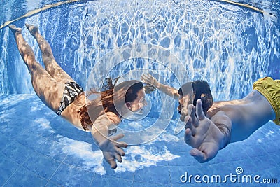 Positive couple swimming underwater in outdoor pool Stock Photo