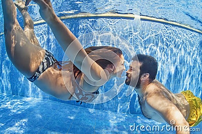 Positive couple swimming underwater in outdoor pool Stock Photo