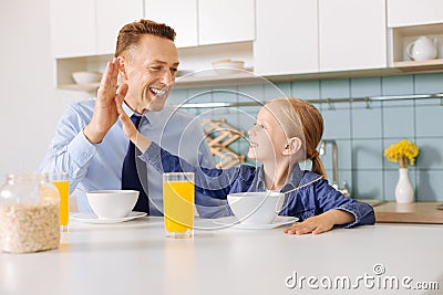 Positive cute girl giving her father high five Stock Photo