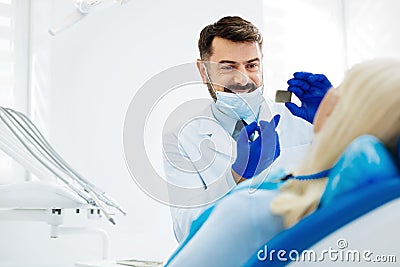 Positive dentist showing dental Xray image to the patient Stock Photo