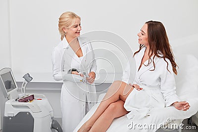 Positive doctor and female client discussing the details of beauty treatment Stock Photo