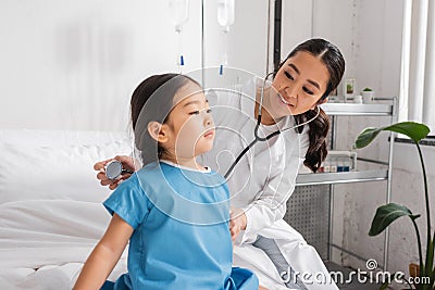 positive doctor with stethoscope examining asian Stock Photo