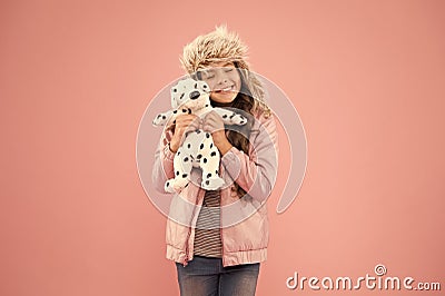 Positive emotions. Happy small smiling child play with soft dog on pink background. Happy little child hold play toy Stock Photo