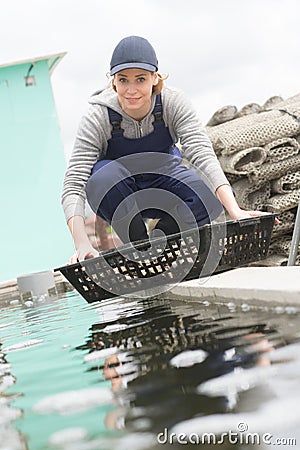 positive european fish farm employee nursing seashells Stock Photo