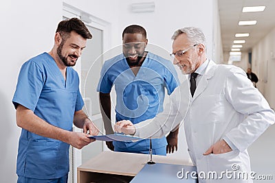 Positive experienced medic checking the quality of work in the hospital Stock Photo