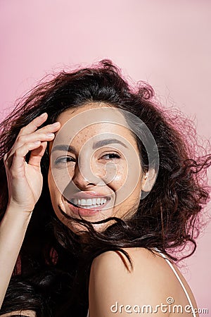 Positive freckled woman touching face on Stock Photo