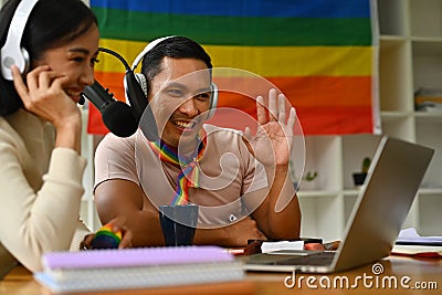 Positive gay male podcaster and friend speaking into microphone, live streaming event, sharing experience Stock Photo