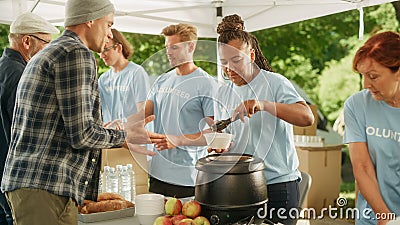 Positive Group of Young Adult Volunteers Serving Free Food for Poor People in Need. Charity Workers Stock Photo