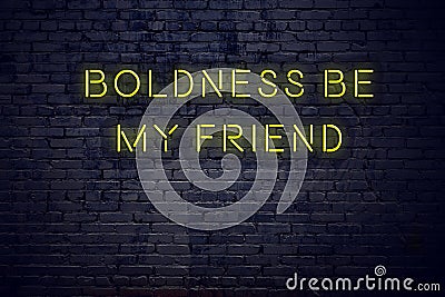 Positive inspiring quote on neon sign against brick wall boldness be my friend Stock Photo