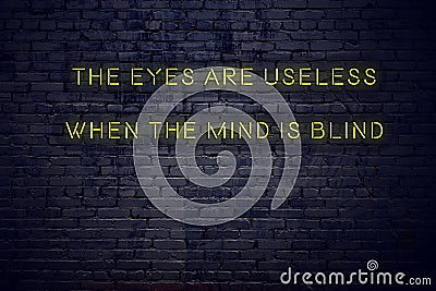 Positive inspiring quote on neon sign against brick wall the eyes are useless when the mind is blind Stock Photo