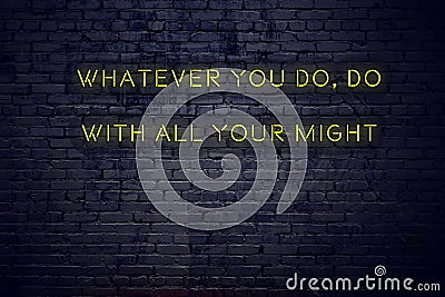 Positive inspiring quote on neon sign against brick wall whatever you do do with all your might Stock Photo