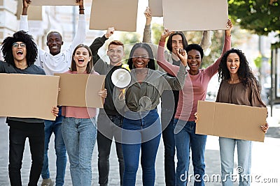 Positive international students walking by street with empty placards Stock Photo