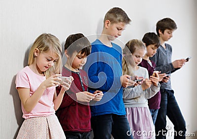 Kids using their mobile phones Stock Photo