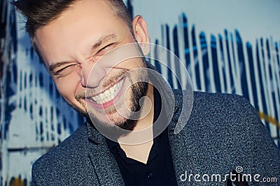 Positive laughing man with a white tooth smile on the background Stock Photo