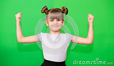 Positive little girl with funny pigtails shows her power biceps with arms raised victory. Winner school girl celebrates success, Stock Photo