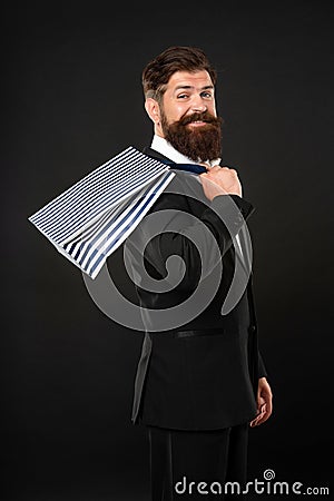 positive man in tuxedo bow tie with business reward in shopping bag. occasion greeting. Stock Photo