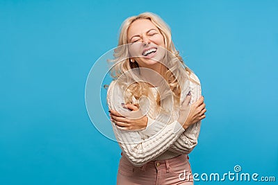 Positive optimistic woman with blond curly hair hysterically laughing enjoying life and freedom, carefree female Stock Photo