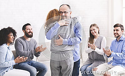 Positive people hugging during group rehab therapy Stock Photo