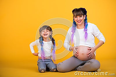 Positive pregnant mother and funny daughter Stock Photo