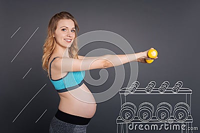 Positive pregnant woman with dumbbels Stock Photo