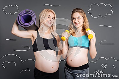 Positive pregnant women getting ready for sport exercises Stock Photo