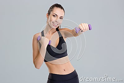 Positive pretty fitness girl exercising with dumbbells Stock Photo