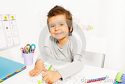 Positive small boy draws with pencil during ABA Stock Photo