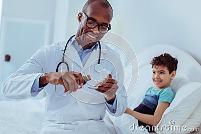 Positive smart doctor pouring mixture in the spoon Stock Photo