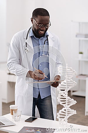 Positive smart scientist holding his notes Stock Photo